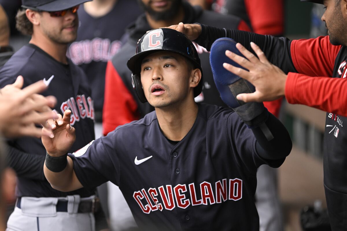 Cleveland Guardians' Steven Kwan is congratulated after scoring against the Kansas City Royals during the first inning of a baseball game, Monday, April 11, 2022, in Kansas City, Mo. (AP Photo/Reed Hoffmann)