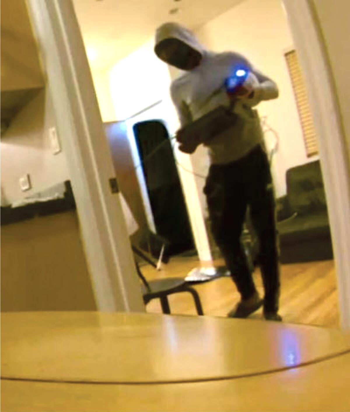 Amazon security camera video screenshot showing man activating stun gun.