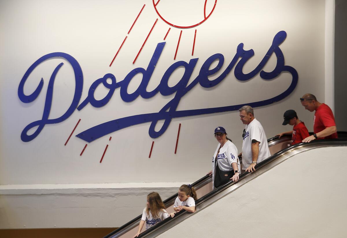 Dodgers fans take an escalator to the field level of Dodger Stadium before the game.