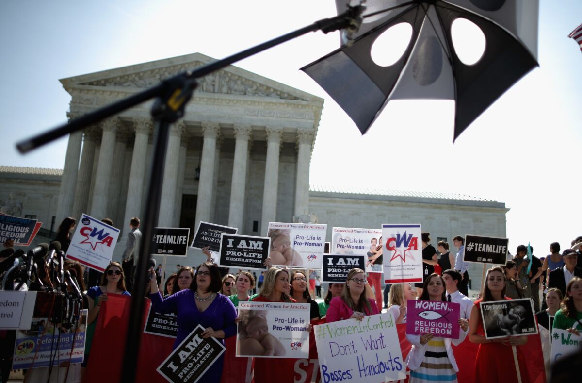 Anti-abortion advocates rally in front of the Supreme Court before the decision in Burwell v. Hobby Lobby Stores was announced Monday.