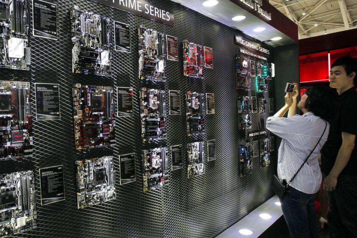 FILE - Visitors review new computer products during the Computex Taipei exhibition at the world trade center in Taipei, Taiwan, Tuesday, May 30, 2017. GlobalWafers Co., which supplies silicon wafers to semiconductor manufacturers, said on Sunday, Feb. 6, 2022, it will invest $3.6 billion in facilities in Asia, the United States and Europe after its attempt to acquire Germany’s Siltronic AG failed. (AP Photo/Chiang Ying-ying, File)
