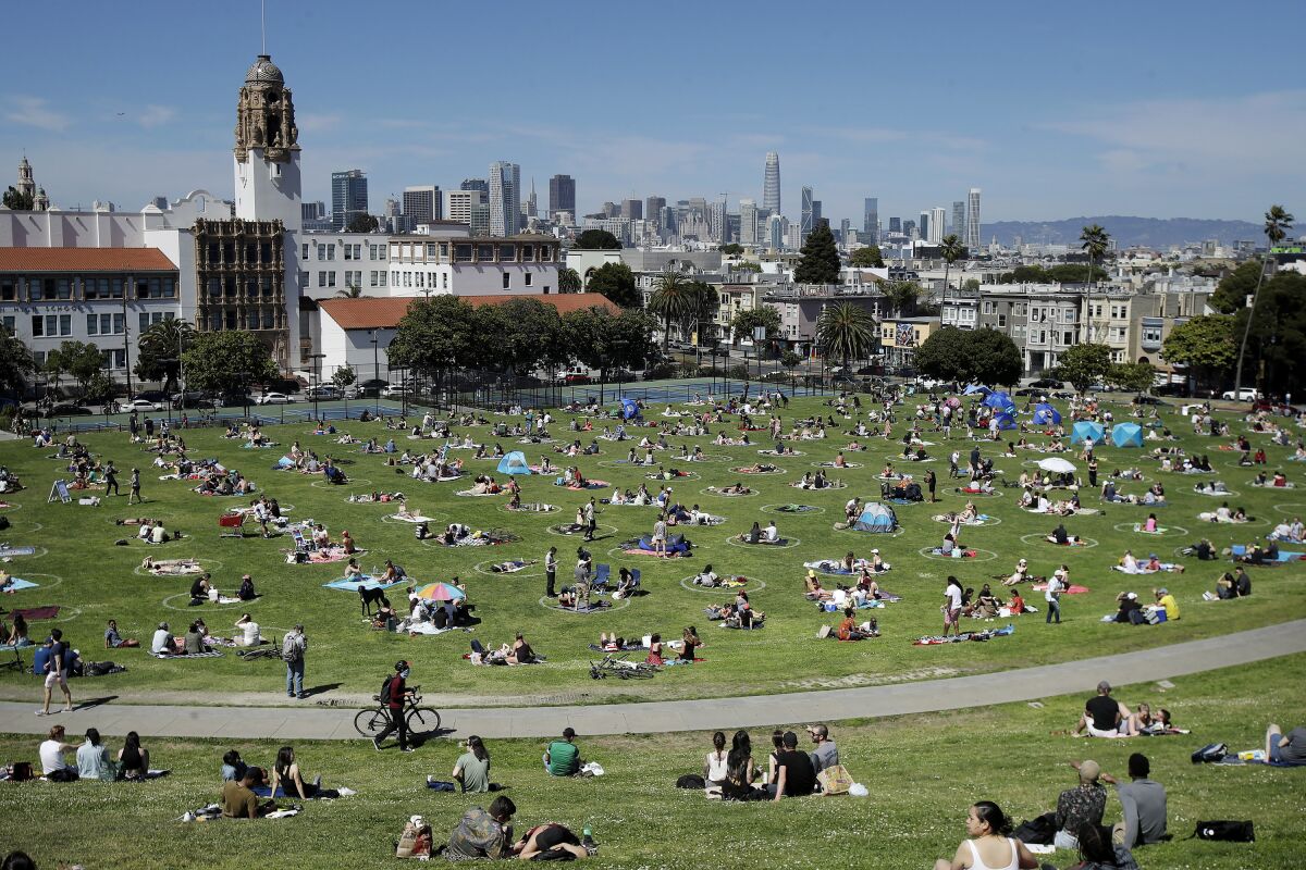 Visitors sit inside circles designed to help prevent the spread of the coronavirus at Dolores Park in San Francisco.