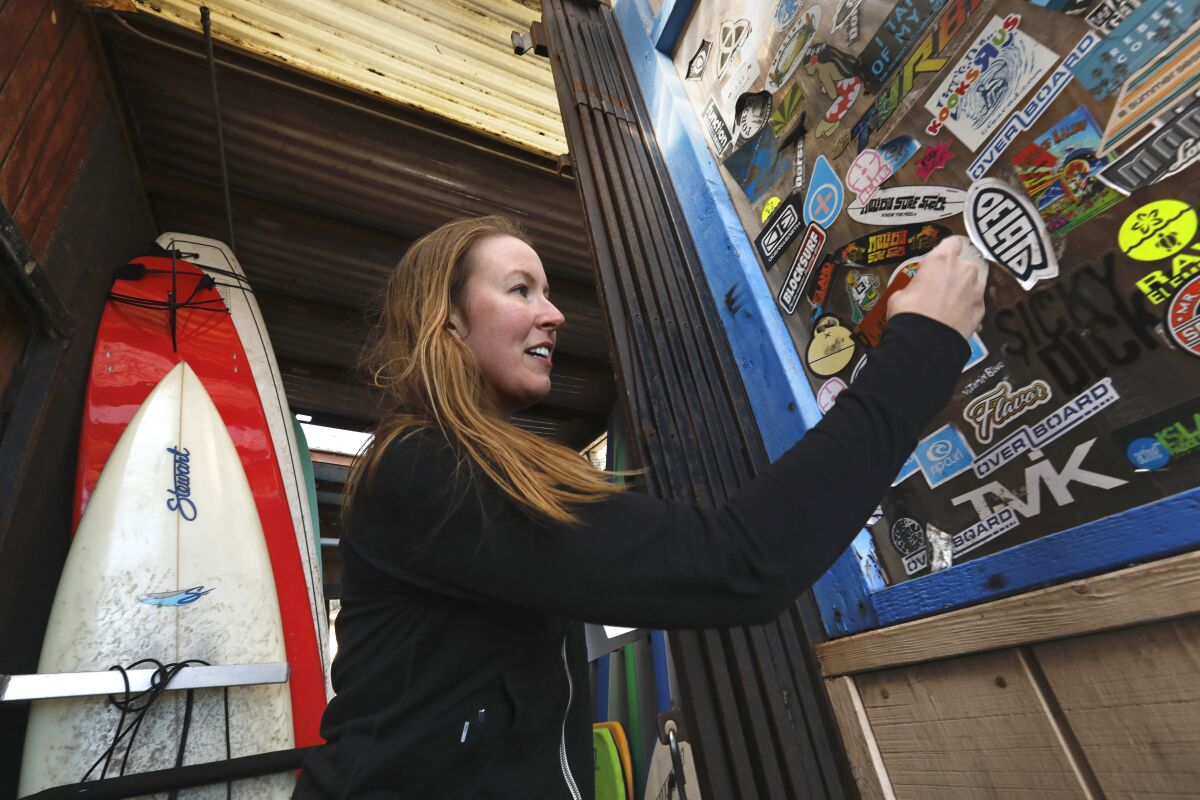 Zoë Kustritz visits the Malibu Surf Shack to hand out stickers designed with her missing brother’s name. 