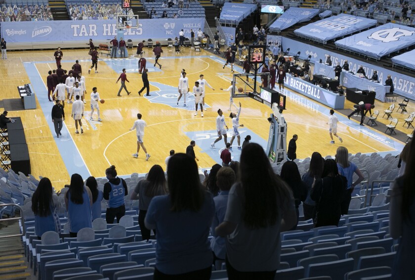 Fans stand as the North Carolina basketball team enters the court for their game against Florida State on Saturday, February 27, 2021 in Chapel Hill, N.C. Under new state CVOID-19 guidelines fans are being allowed into the game. Approximately 2400 students were given tickets.(Robert Willett/The News & Observer via AP)