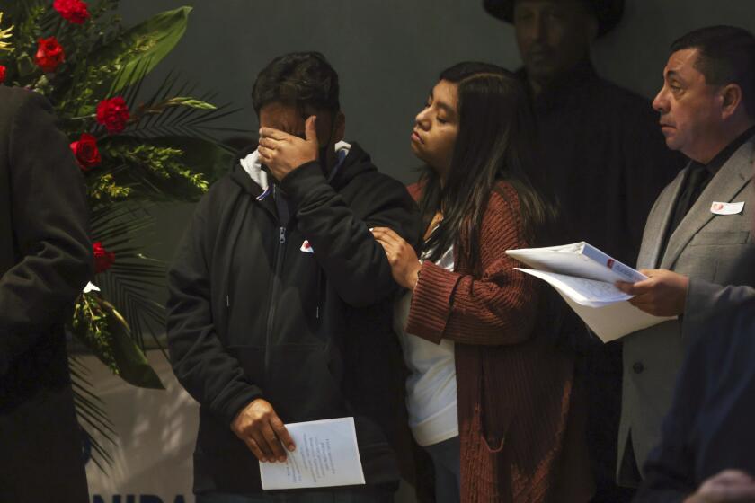 Moments after Servando Martinez Jiminez, left, spoke about his brother Marciano Martinez Jiminez who was killed in the Half Moon Bay shootings, he is comforted by his daughter Marisela Martinez- Maya, center, at a community vigil for the Half Moon Bay shootings in Half Moon Bay, Calif., on Friday, Jan. 27, 2023. (Gabrielle Lurie/San Francisco Chronicle via AP)