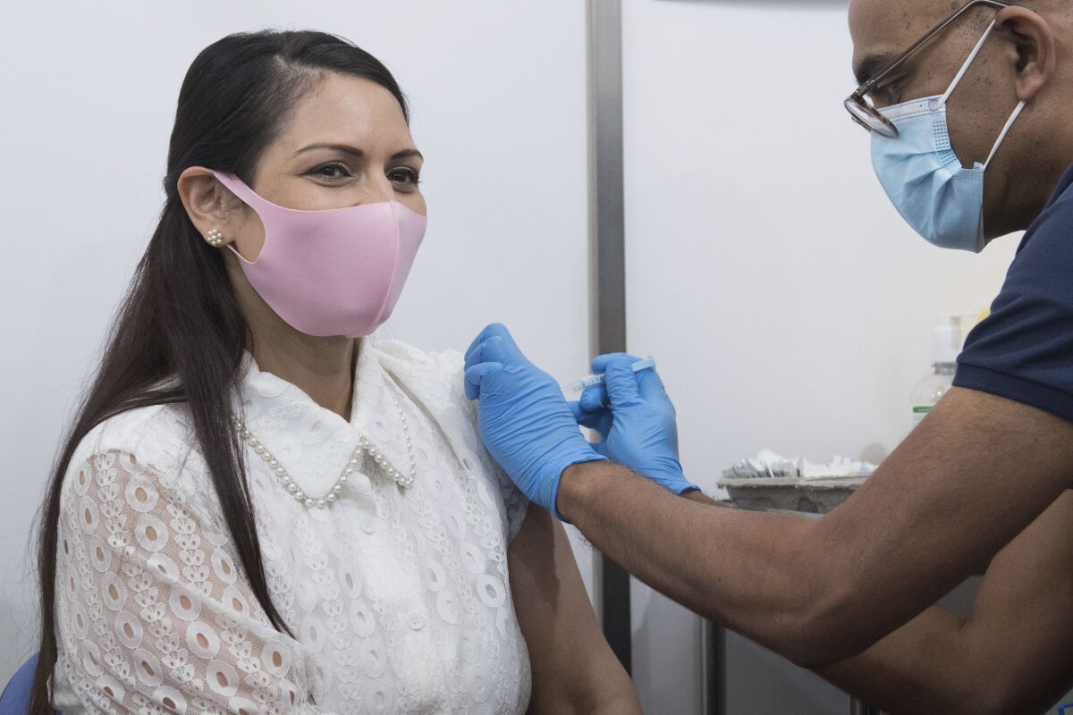 Britain's Home Secretary Priti Patel receives her first dose of the Moderna Covid-19 vaccine from Dr. Vin Diwakar at Guys Hospital in London, Saturday May 15, 2021. (Stefan Rousseu/PA via AP)