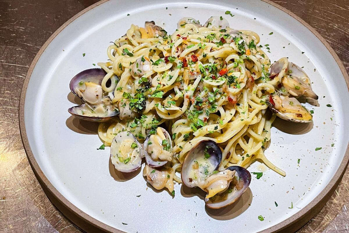 A plate of spaghetti alle vongole, clams front and center, from wine bar and restaurant Mona Pasta Bar.
