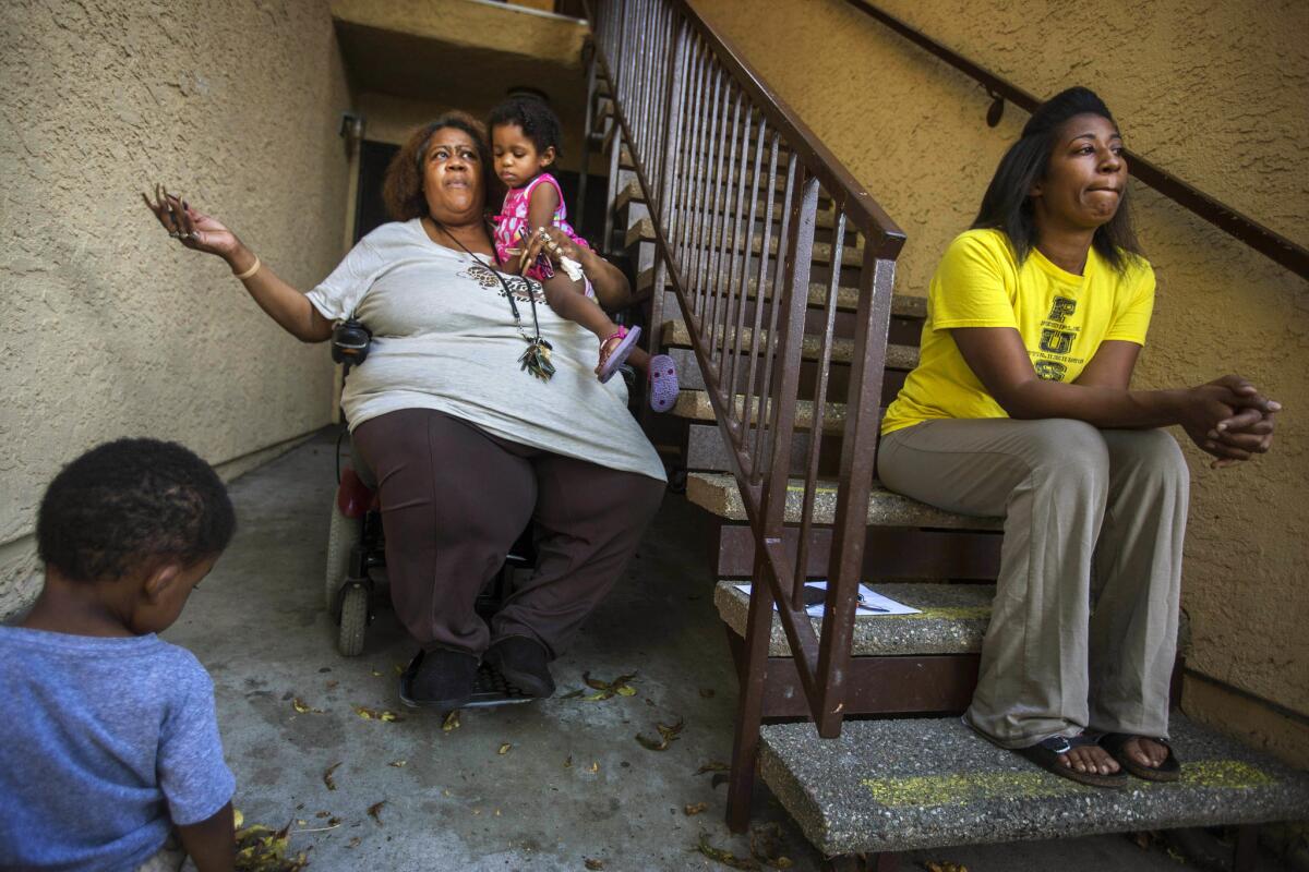 Patricia Richardson, holding her granddaughter, Daicee Nicholson, sits with her daughter, Patrice Richardson, at the Rolland Curtis Gardens housing complex in South Los Angeles.