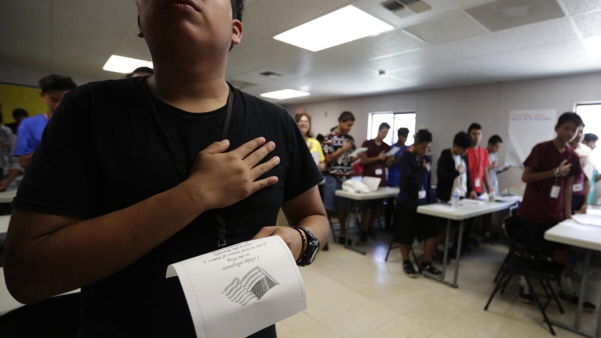 Immigrants say the Pledge of Allegiance at the U.S. government's newest shelter for migrant children in Carrizo Springs, Texas.