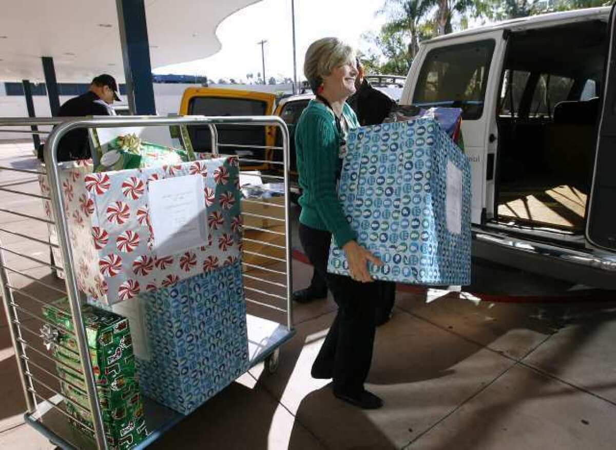 Glendale Memorial Hospital's Nancy Sumner loads a large box of gifts that were to be donated to families at Cerritos Elementary School. Hospital employees from 47 departments donated gifts for 28 families from the local school.