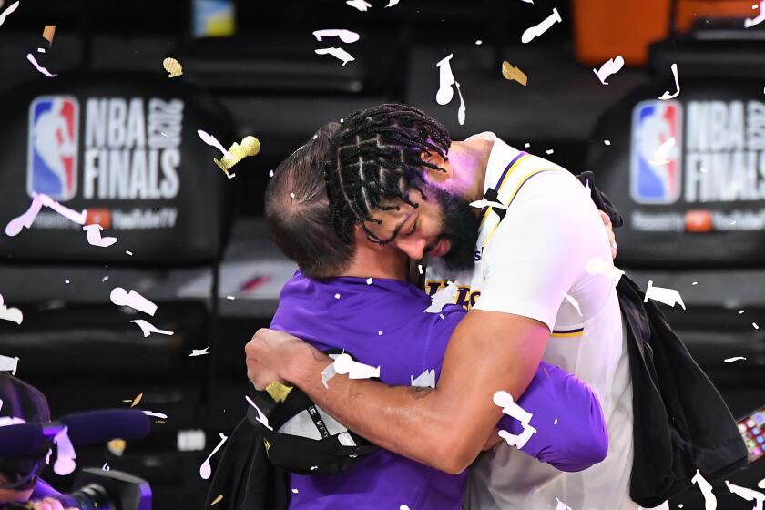 ORLANDO, FLORIDA OCTOBER 11, 2020-Lakers Anthony Davis gets a hug afetr wining the NBA Championship in Game 6 of the NBA FInals in Orlando Sunday. (Wally Skalij/Los Angeles Times)