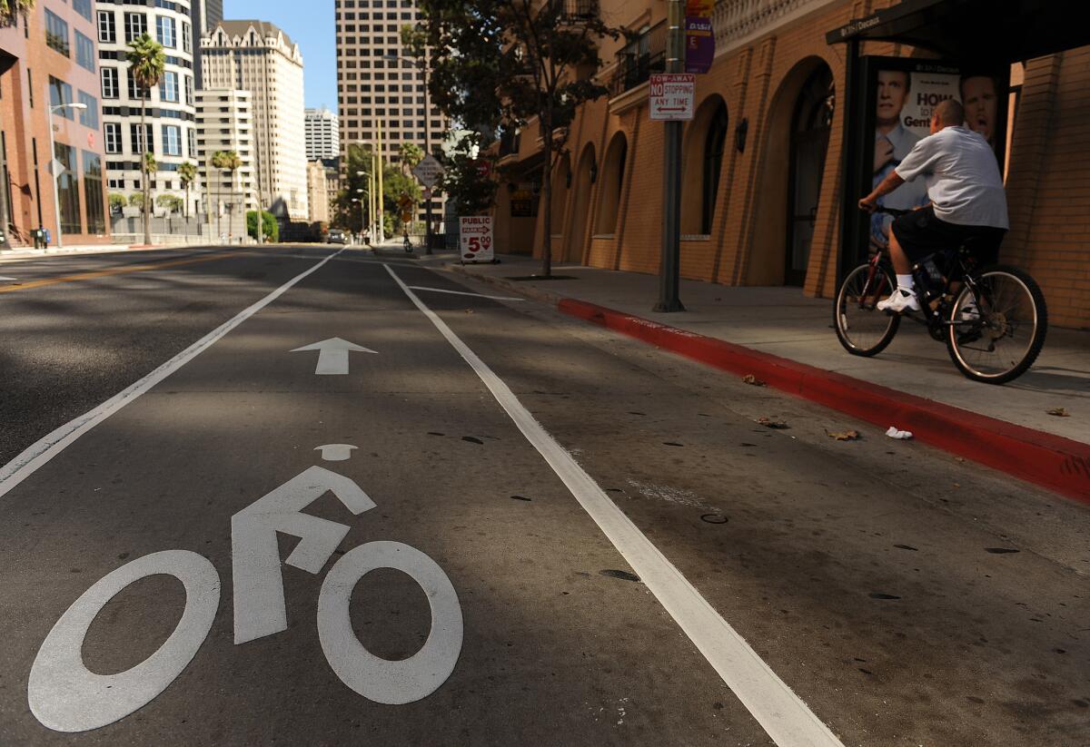 A byclist rides on the sidewalk despite the new commuter bike lane on 7th Street in downtown Los Angeles.