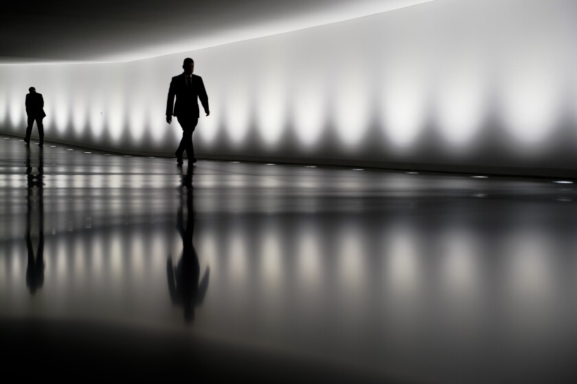 Two persons walk through a tunnel between the plenary hall and an office building of the German parliament Bundestag in Berlin, Germany, Wednesday on March 25, 2020.