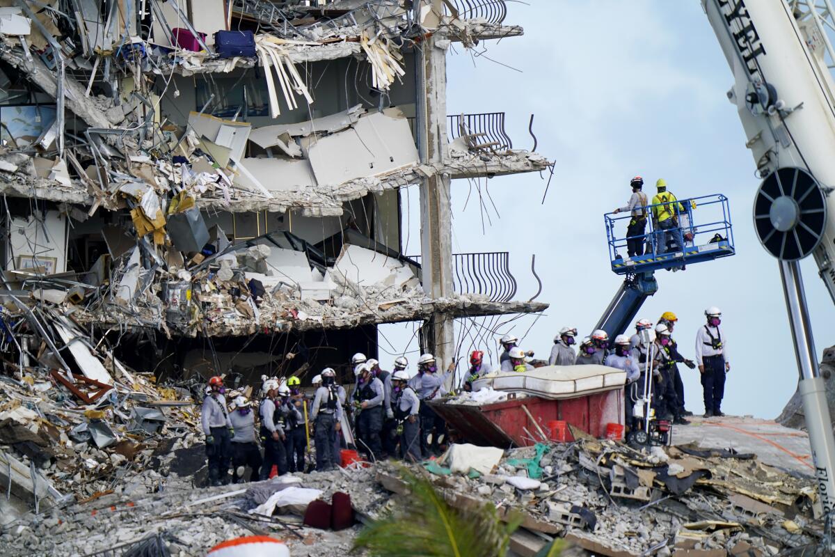 Workers search the rubble at the Champlain Towers South Condo