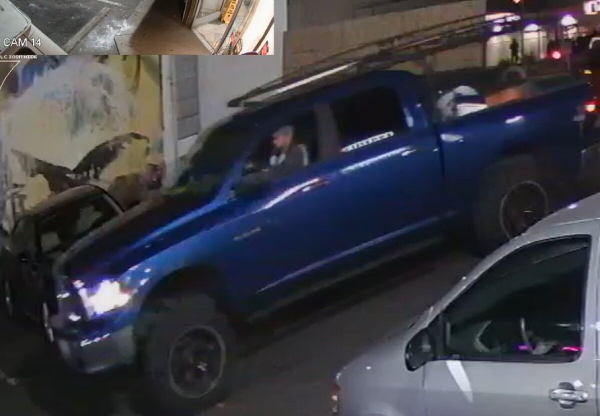 A man driving a blue Dodge Ram pickup truck with a rack in the bed