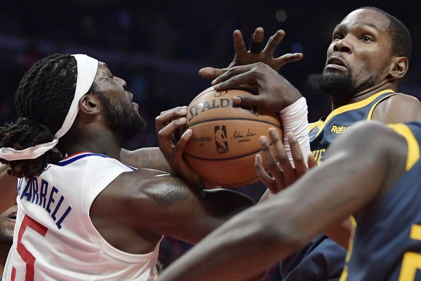 Los Angeles Clippers forward Montrezl Harrell, left, and Golden State Warriors forward Kevin Durant grapple for the ball during the second half of an NBA basketball game, Monday, Nov. 12, 2018, in Los Angeles. The Clippers won 121-116 in overtime. (AP Photo/Mark J. Terrill)