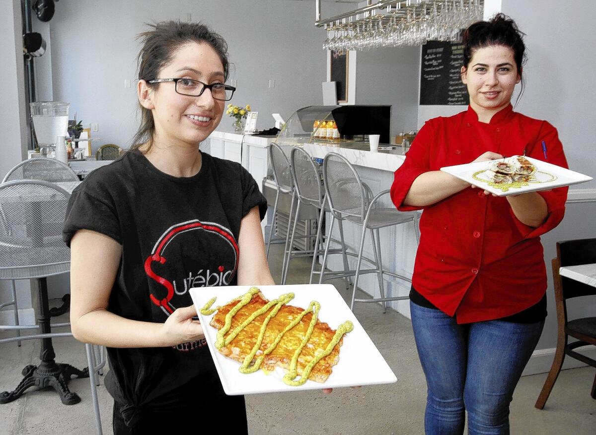 Sustebia restaurant owner Stephanie Alishan, left, holds the Sangak quesadilla while chef Diana Gasparyan, right, who shows off the steak wrap in Glendale on Thursday, July 17, 2014.
