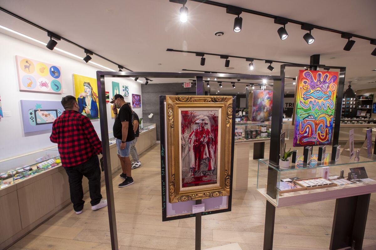 People look at art in a gallery that is also a cannabis dispensary.