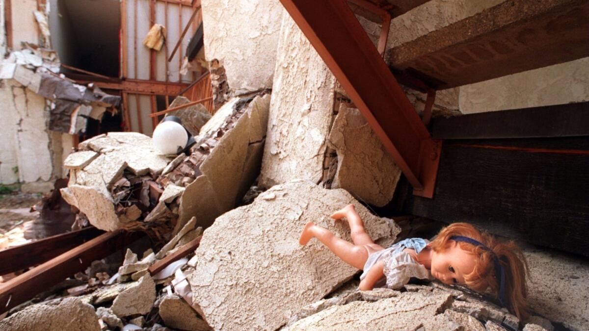 A doll lies in the rubble of the Northridge Meadows apartment, where 16 bodies were found after 1994 Northridge earthquake. (Richard Derk / Los Angeles Times)