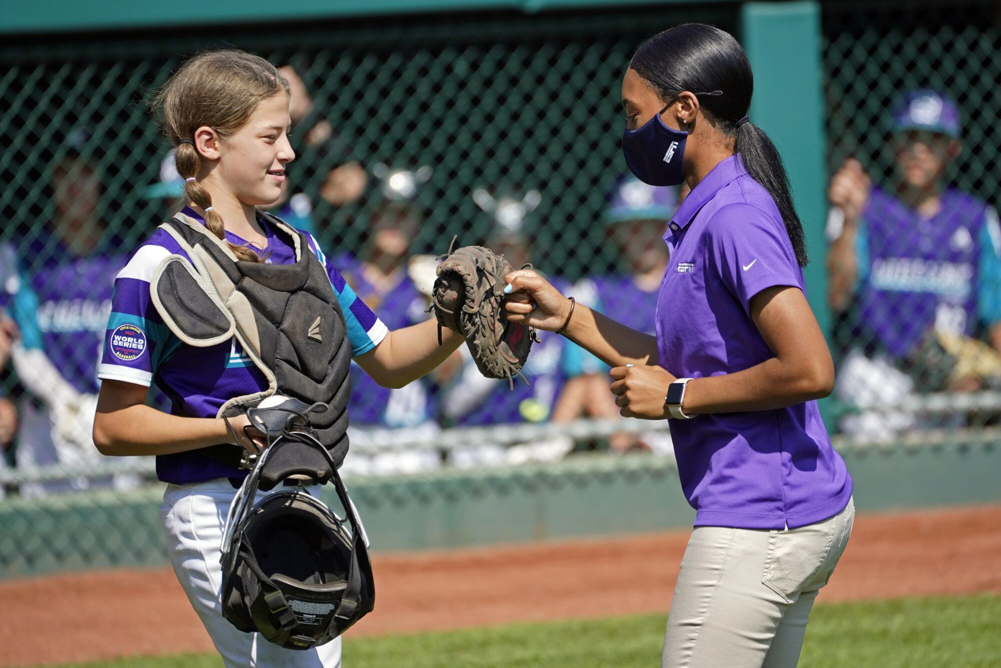 Abilene, Texas catcher Ella Bruning (8) fist bumps with Mo'ne Davis after Davis threw out the first pitch.