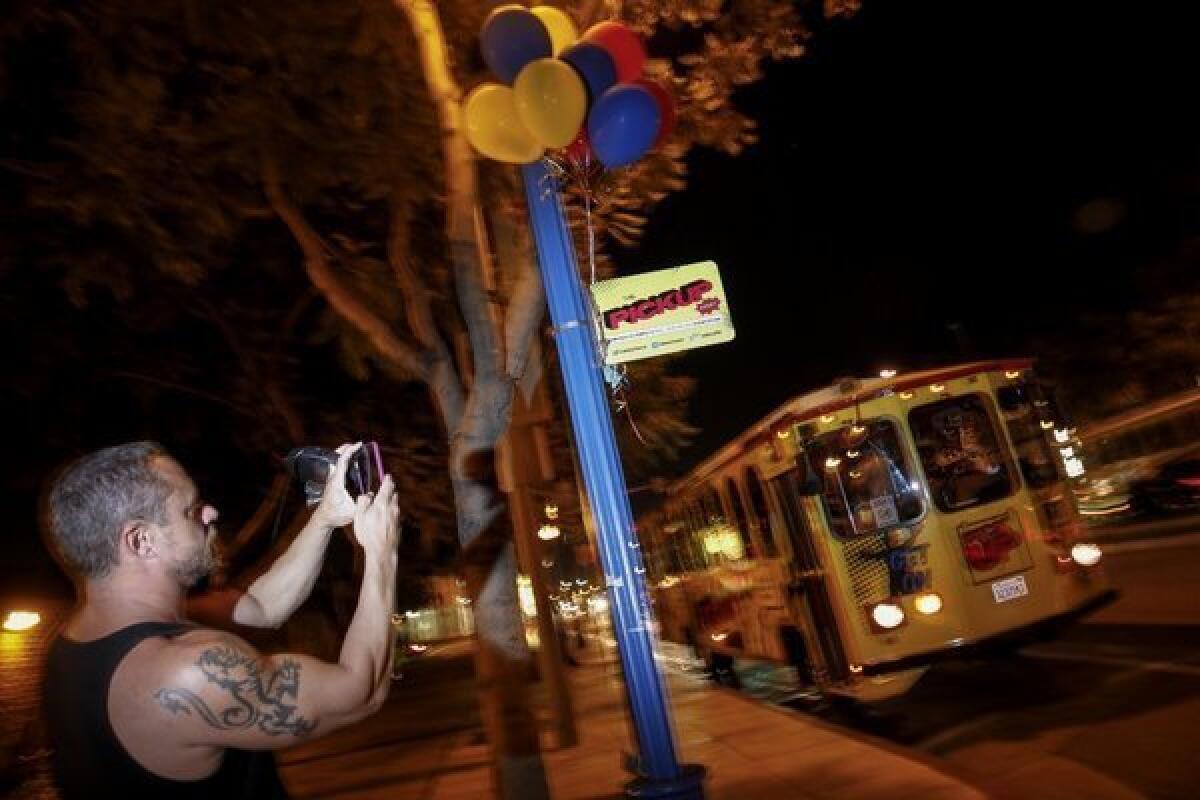 Max Bruce snaps a picture of a PickUp trolley near a stop on Santa Monica Boulevard in West Hollywood.