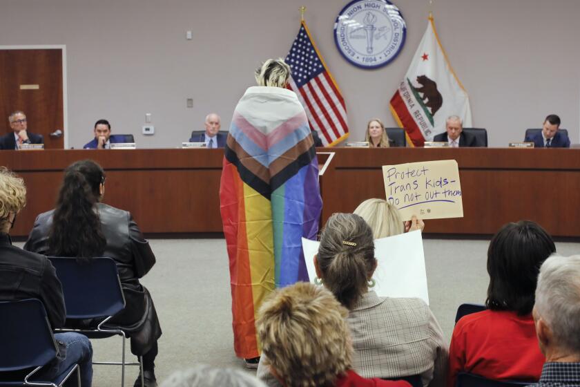 Escondido, CA - November 14, 2023_ During a meeting of the Escondido Union High School District Amelia Mester, a district teacher's aid, wrapped herself in a pride flag as she urged the district not to notify parents if they feel a student is transgender. (Charlie Neuman / For The San Diego Union-Tribune)