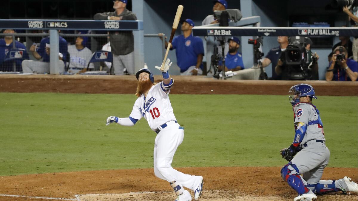 Justin Turner releases his bat in the air after flying out with a runner on base.
