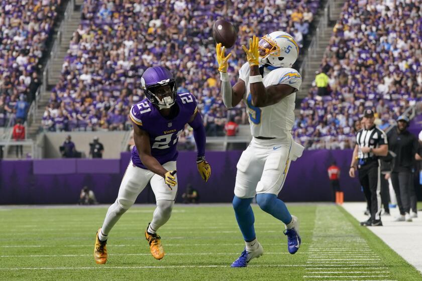 Los Angeles Chargers wide receiver Joshua Palmer (5) catches a pass in front of Minnesota Vikings cornerback Akayleb Evans (21) during the first half of an NFL football game, Sunday, Sept. 24, 2023, in Minneapolis. (AP Photo/Abbie Parr)