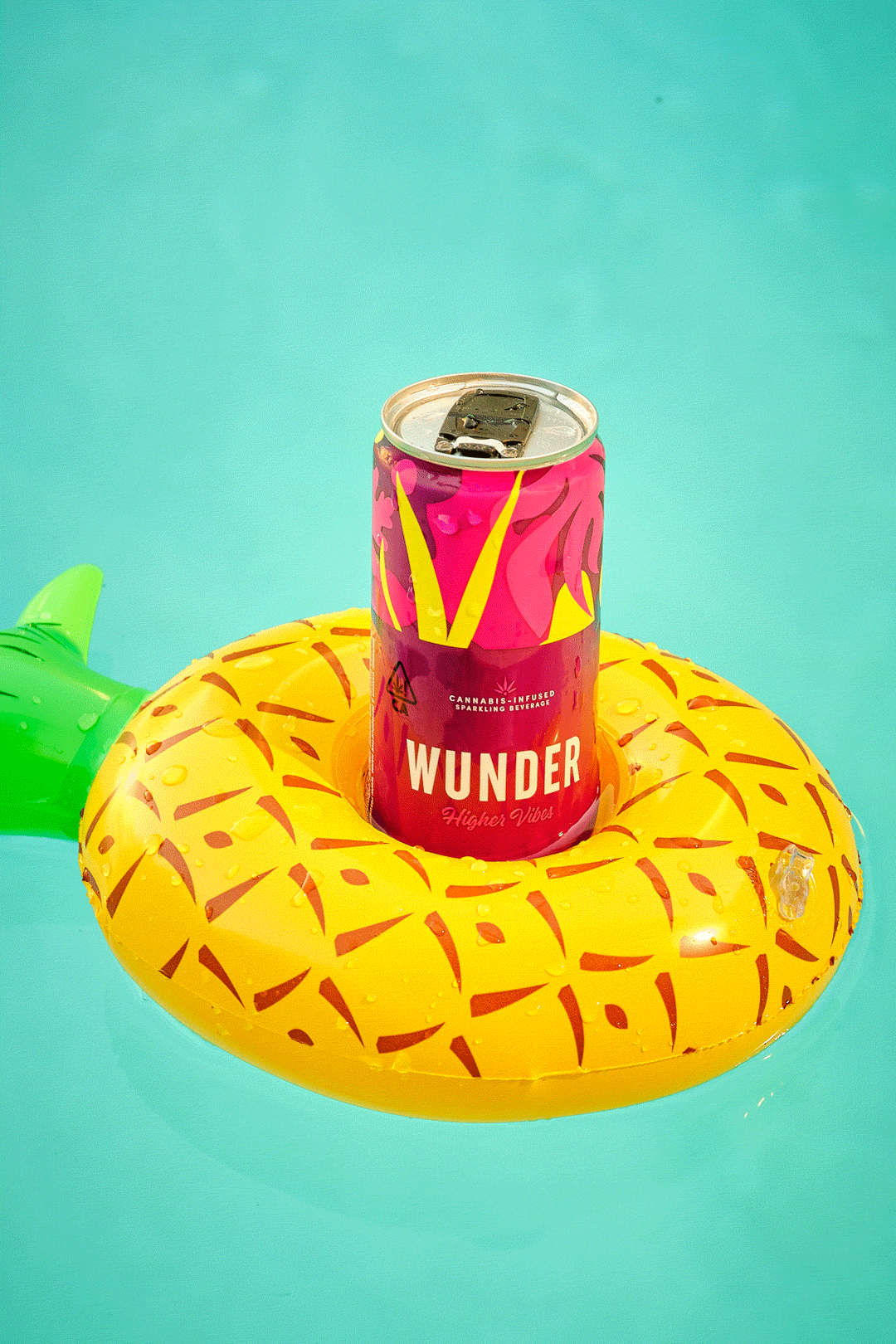 A beverage can floating in a pineapple-shaped pool float.