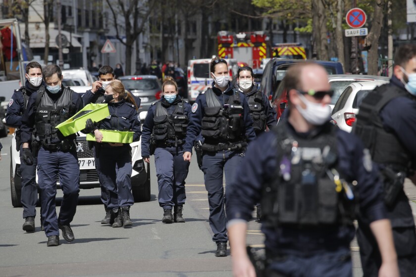 Police officers leave the scene after a shooting Monday, April 12, 2021 in Paris. A gunman has shot two people in front of a hospital in Paris and the attacker fled on a motorcycle. (AP Photo/Christophe Ena)