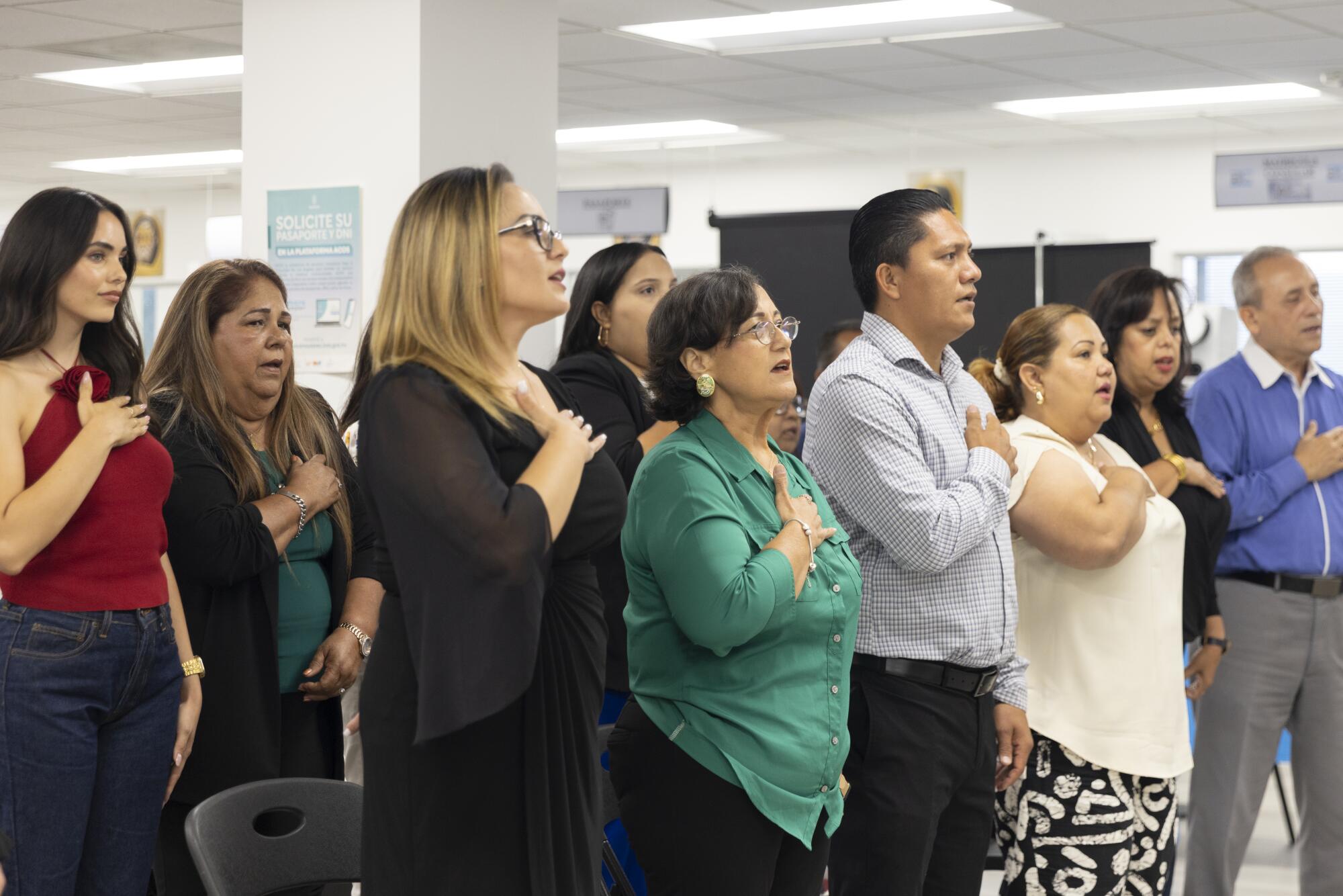 Las personas invitadas entonan el himno nacional de Honduras en la apertura de las nuevas consulares.