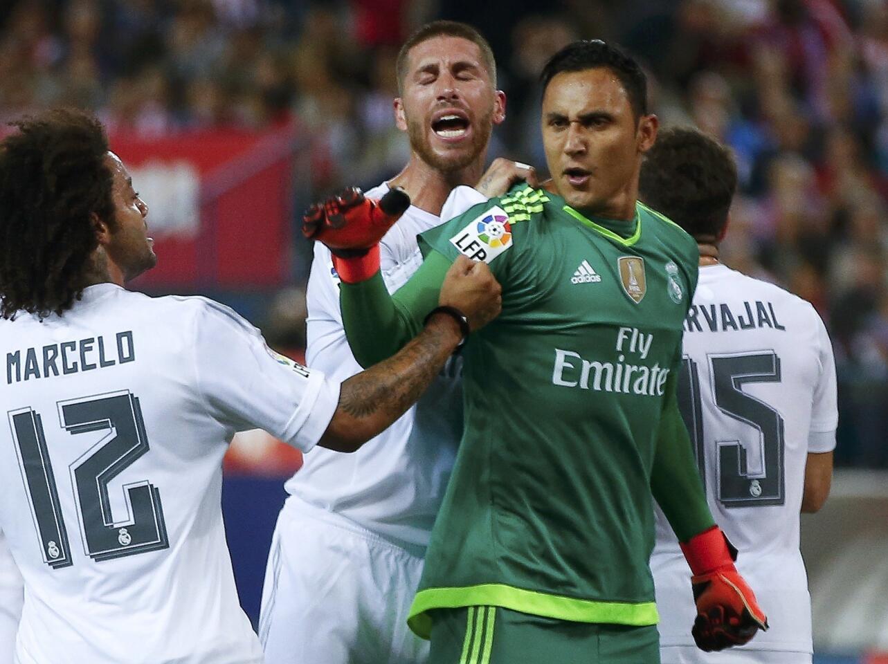 Real Madrid's goalkeeper Keylor Navas is congratulated after saving a penalty kick during their Spanish first division derby soccer match in Madrid