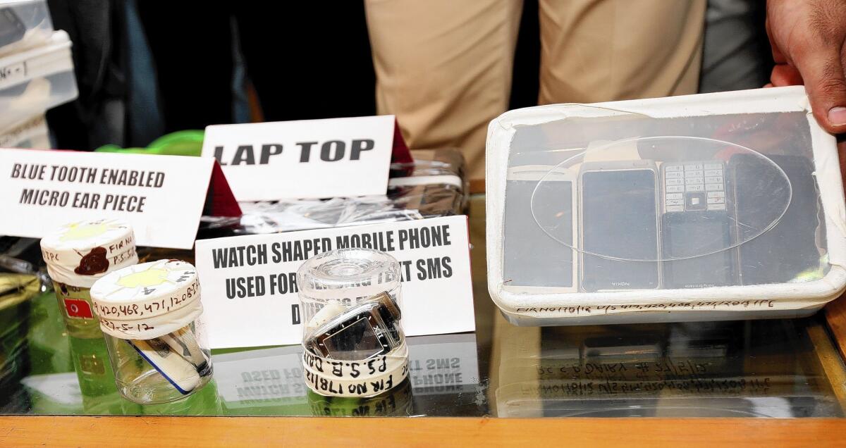 Police in 2012 display sophisticated gadgets seized in a major test cheating scandal in New Delhi.