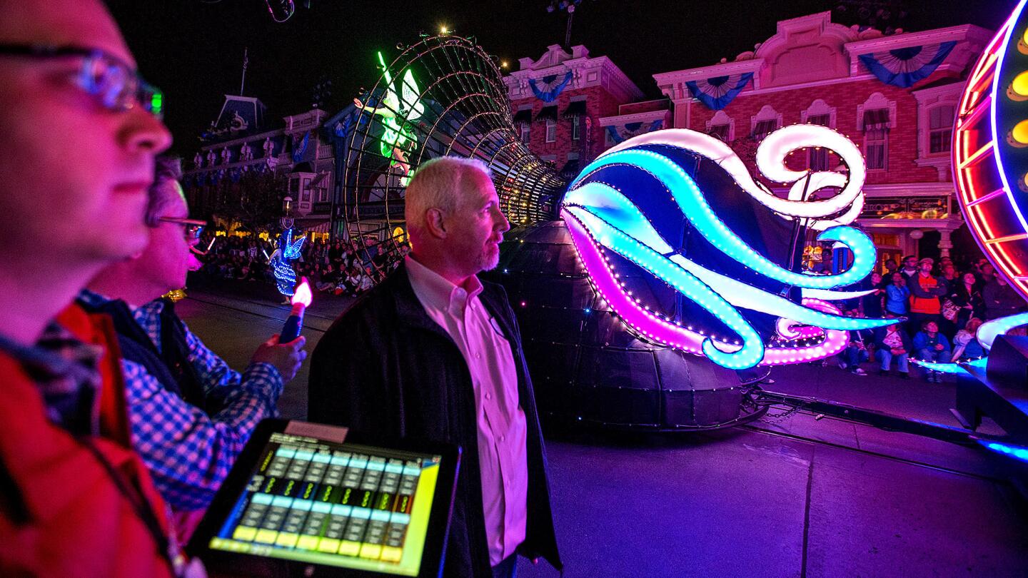Ryan Hunter, left, entertainment controls engineer, and Chuck Davis, senior technical director for entertainment, right, use a tablet to monitor projection mapping on Main Street U.S.A. buildings and Paint The Night parade movement during a dress rehearsal for Disneyland's 60th diamond anniversary celebration Tuesday, May 19, 2015. Disneyland is relying heavily on new technology for its new parade and fireworks show for its 60th anniversary celebration.