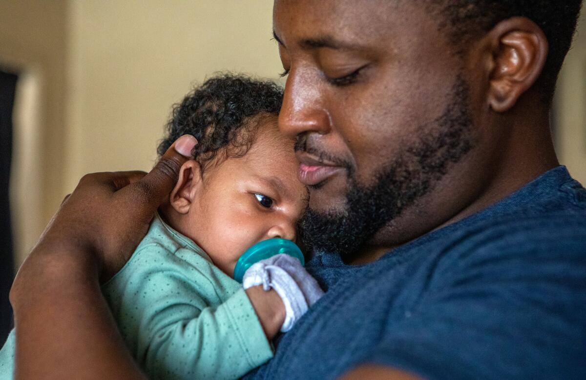 Danny Rollins, 32, holds his newborn Braylen Rollins in their home on Thursday, June 15, 2023, in Compton, CA. 