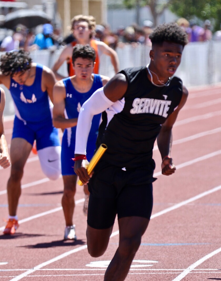 Servite's Max Thomas takes the baton for the final leg of the 1,600-meter relay.