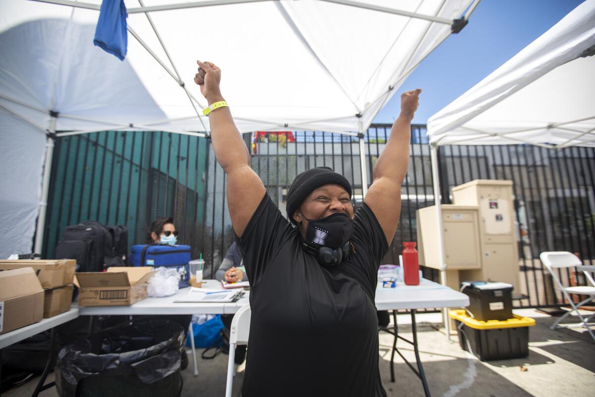 Jasmine Daughtry, 31, throws her arms in the air after being vaccinated on Aug. 4, 2021 on skid row in Los Angeles.