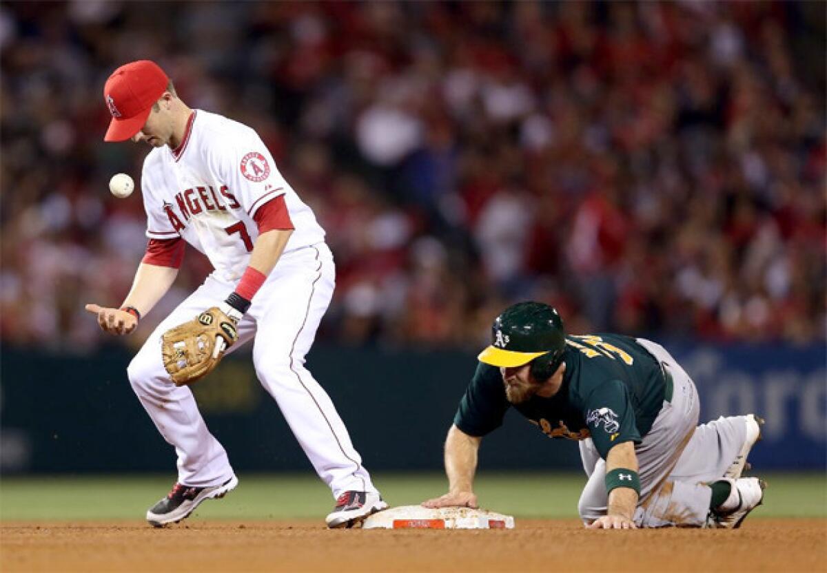 Angels shortstop Andrew Romine bobbles the ball as Oakland A's catcher Derek Norris steals second base.