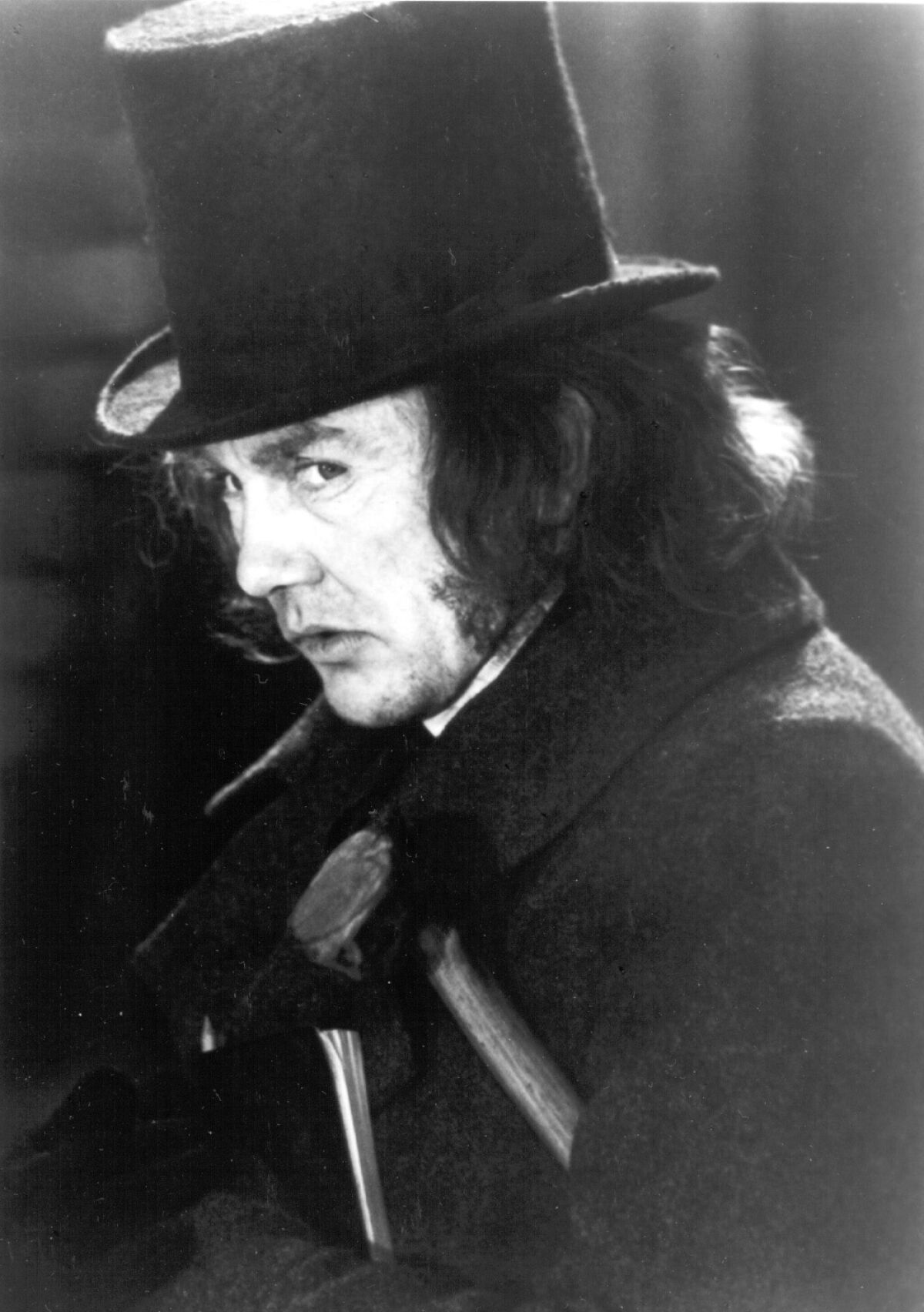 a black-and-white photo of albert finney in profile wearing a top hat