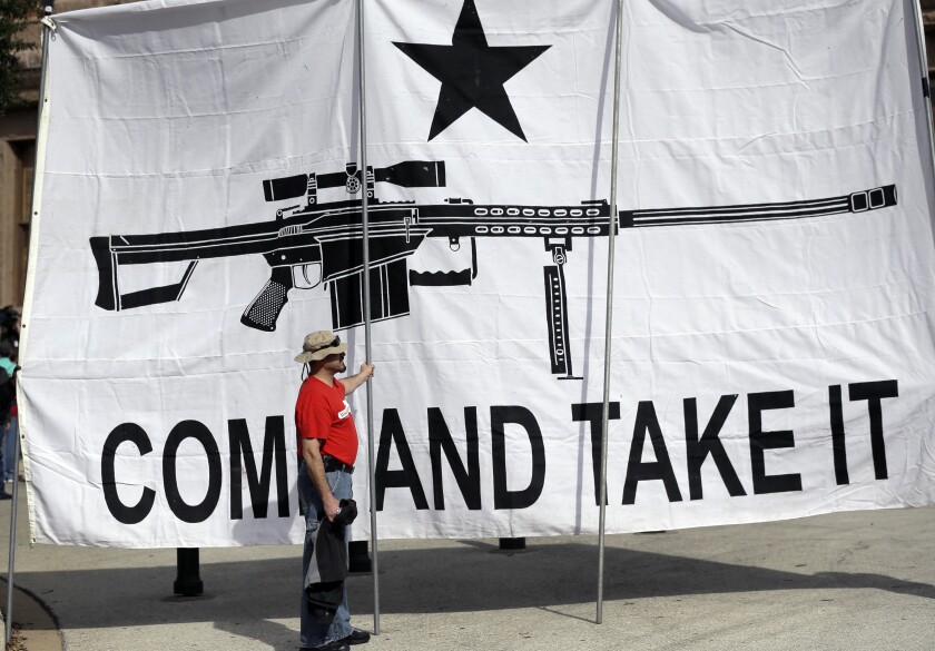A man who supports open-carry gun laws displays a banner during a rally in Austin, Texas, in 2015.