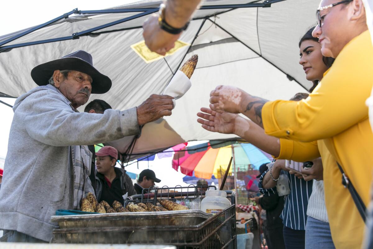 Candelario Padilla, 85, sells roasted corn, one of the favorite offerings at the Piñata District street food market in downtown Los Angeles.