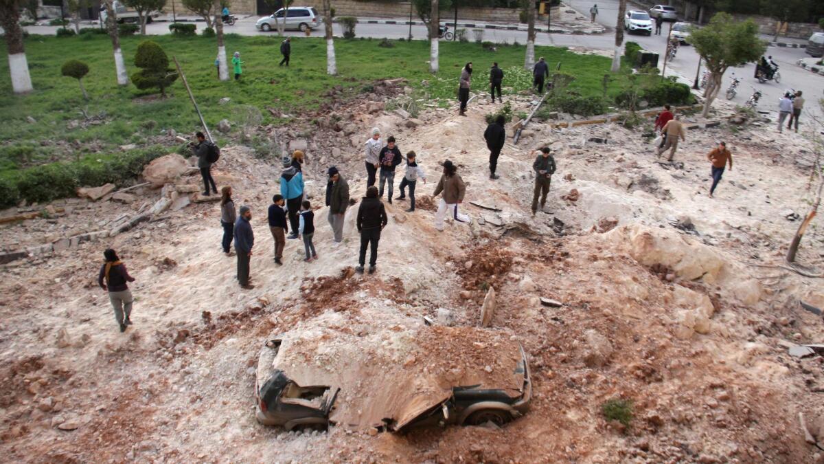 Syrians gather at the site following an airstrike on the northern Syrian city of Idlib.
