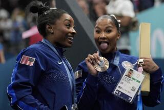 Jordan Chiles, right, joyously shows off her bronze medal next to Simone Biles