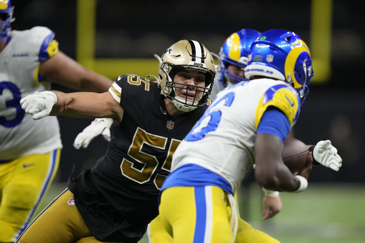 Saints linebacker Kaden Elliss (55) fires Rams quarterback Bryce Perkins (16) in the second half.