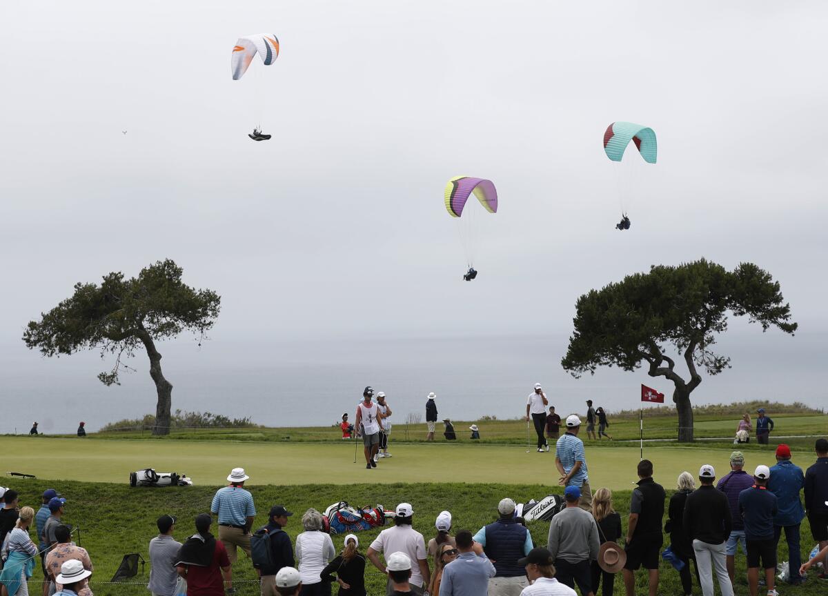 Paragliders fly near the fourth hole during the second round of the U.S. Open.