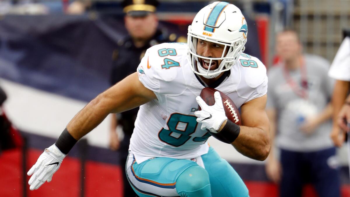 Dolphins tight end Jordan Cameron looks for running room after making a reception against the Patriots during a game earlier this season.