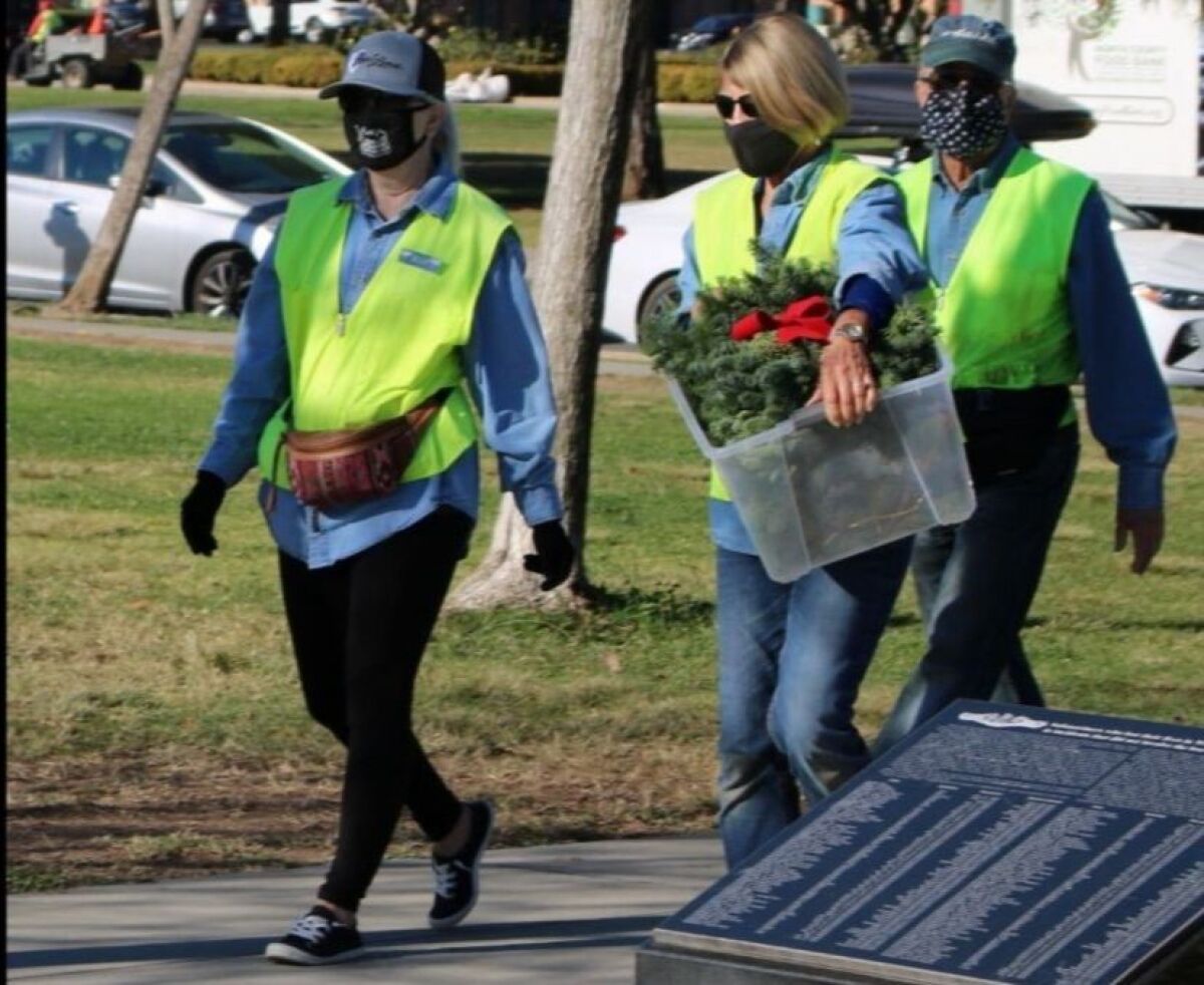 Members of the Point Loma Association's Mean Green Team deliver wreaths to Liberty Station's 52 Boats Memorial.