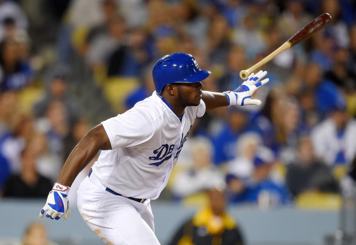 Yasiel Puig tosses his bat after hitting an RBI double in the seventh inning of the Dodgers' 6-3 win over the Colorado Rockies.