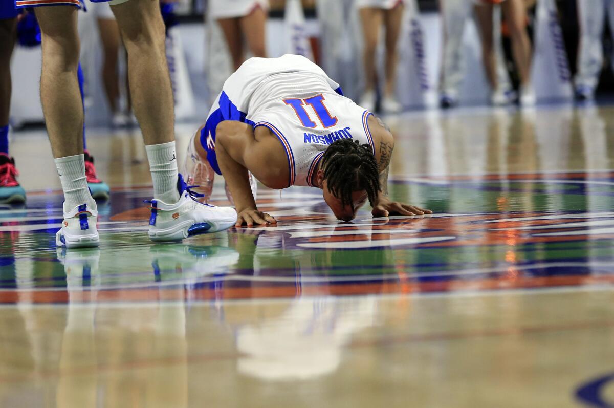 Florida forward Keyontae Johnson (11) kisses the floor at midcourt after being introduced as a starter before an NCAA college basketball game against Kentucky, Saturday, March 5, 2022, in Gainesville, Fla. (AP Photo/Matt Stamey)