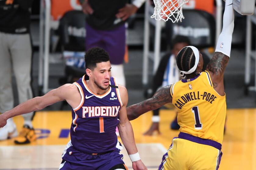 Lakers guard Kentavious Caldwell-Pope scores a basket in front of Suns guard Devin Booker on May 27, 2021.